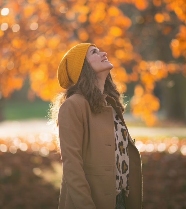Image of women looking up at the trees on a sunny fall day